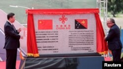 资料照:2018年11月16日,在巴布亚新几内亚莫尔兹比港举行的亚太经合组织峰会之前,中国国家主席习近平(左)和巴布亚新几内亚总理彼得·奥尼尔在中国援巴新独立大道项目开幕式上揭牌。