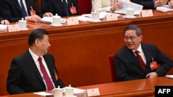 2024年3月5日,中国国务院总理李强(右)在中国人大开幕式上做完工作报告后与中国国家主席习近平(左)交谈。