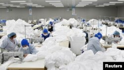 中国安徽省巢湖一家工厂的工人为抗击新冠病毒疫情在赶制防护服。(2020年1月28日)
