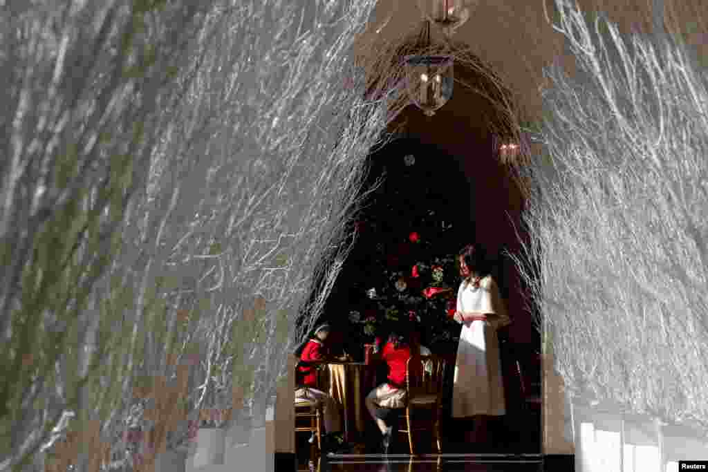2017年11月27日,华盛顿白宫,第一夫人梅拉妮亚·川普(Melania Trump)欢迎那些来到白宫制作圣诞装饰品的儿童,旁边是作为圣诞节装饰的白色树枝。装饰的主题为“悠久传统”。
