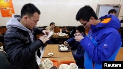 在北京庆丰包子铺,食客们在品尝习近平“亲民”吃过的包子之前用手机拍照。