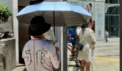 有白衣人支持者不满法官判处7名涉及7-21暴动案的被告入狱3年半至7年,有人辱骂法官,有人在外套背部写上广东话谐音”狗官”的大字(美国之音/汤惠芸)