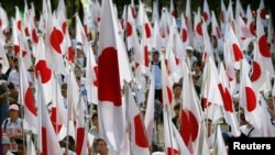 资料照:日本民众手举国旗在东京参加抗议中国对尖阁列岛声索主权的集会。(2012年9月22日)