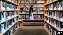 香港一些泛民主派人士撰写的书籍近日遭政府公共图书馆下架。一位女士2020年7月4日在香港一家公共图书馆内。