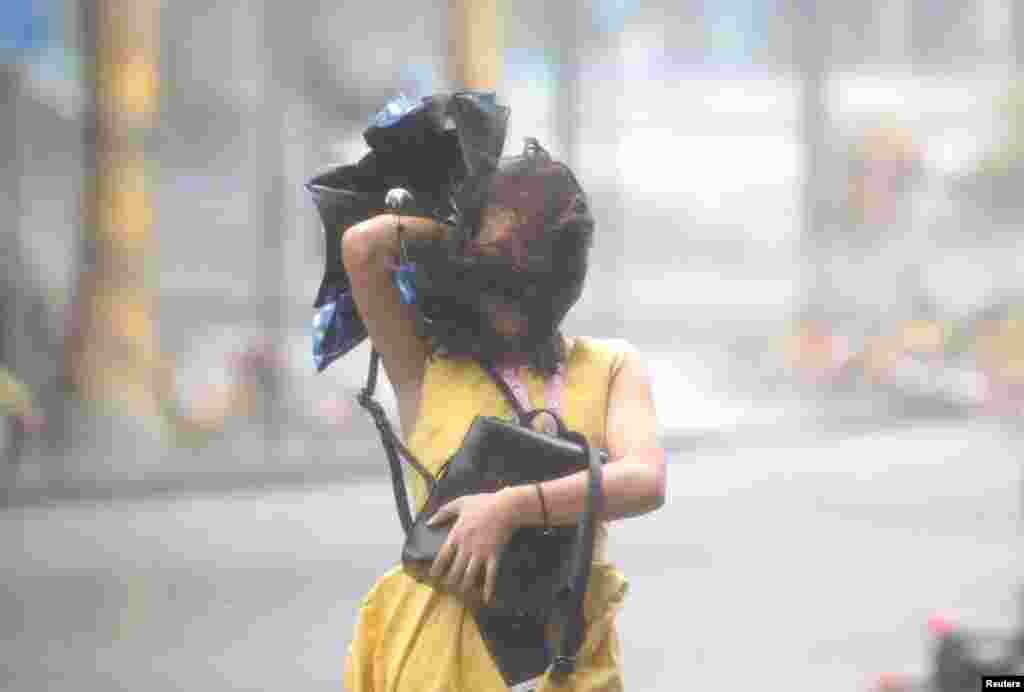 2018年9月16日,在中国深圳,台风山竹逼近,一名女子在暴雨中行走。“山竹”是今年以来全球最强风暴,最大风速几乎是美国“佛罗伦萨”飓风的两倍。