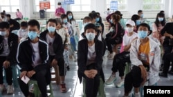 中国黑龙江黑河12岁到14岁的中学生们在接种新冠疫苗期间坐在观察室内等候。(2021年8月3日)