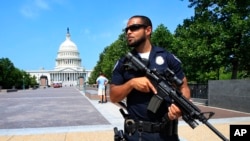 在美国联邦众议院多数党党鞭斯考利斯在维吉尼亚州亚历山大市棒球场遭枪手开枪打伤后,一位国会警察在国会大厦附近站岗(2017年6月14日)