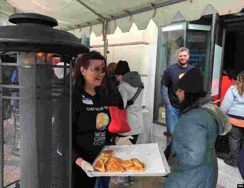 联邦政府部分关门状态进入第33天,慈善组织世界中央厨房的志愿者为排长队领取免费午餐的无薪联邦员工分发热甜点。