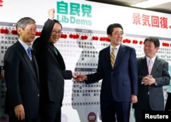 日本首相安倍晋三(中右)等人在选举之夜的活动中。