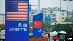 资料照:中国山东青岛商店外的中国和美国国旗。(2018年9月19日)