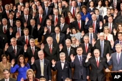 在第114届国会开会第一天,国会众议院共和党一侧成员举手宣誓就职。(2014年1月6日)