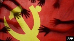 中国江苏连云港的一所小学校的学生在上中共党史课时把手放在中共党旗上。(2020年6月28日)