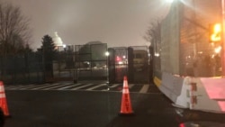 资料照片:夜幕降临被高高的围栏所远远环绕的国会山。(2021年2月15日)