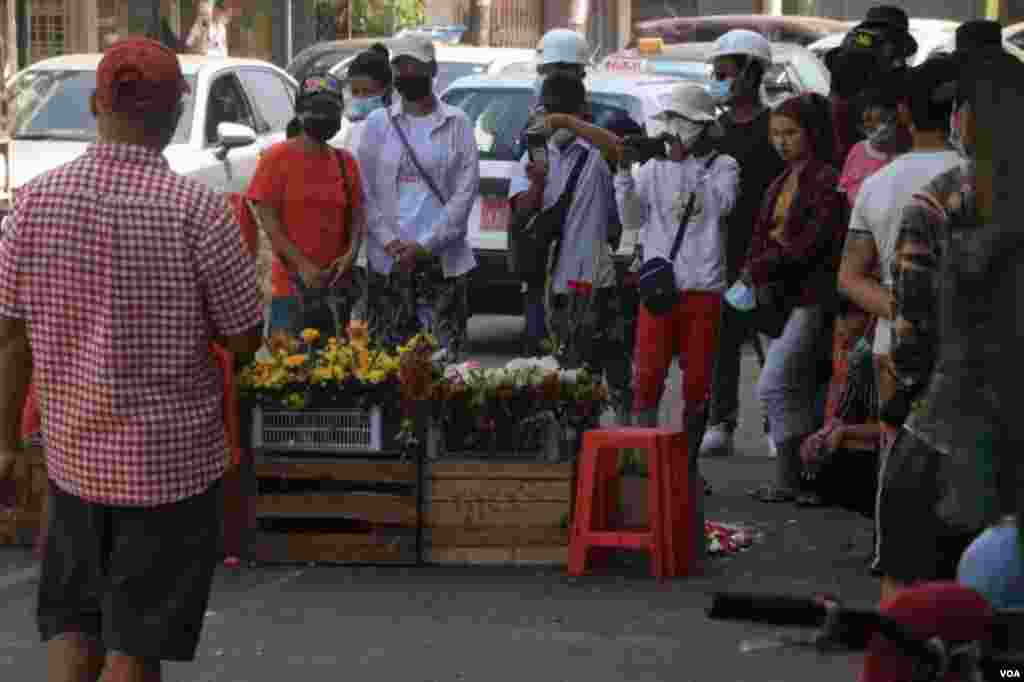 ရန်ကုန် ဆန္ဒပြပွဲအတွင်း သေနတ်ထိမှန်သေဆုံးသူများကို ၎င်းတို့ ကျဆုံးခဲ့ရာနေရာများမှာ ပန်းစည်း ပန်းခြင်းများနဲ့ အောက်မေ့ဂုဏ်ပြုခဲ့ကြတဲ့ မြင်ကွင်း။ (မတ် ၀၁၊ ၂၀၂၁)