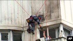 视频截图显示调查人员正在查看莫斯科一栋被乌克兰无人机袭击的建筑。(2023年5月30日)