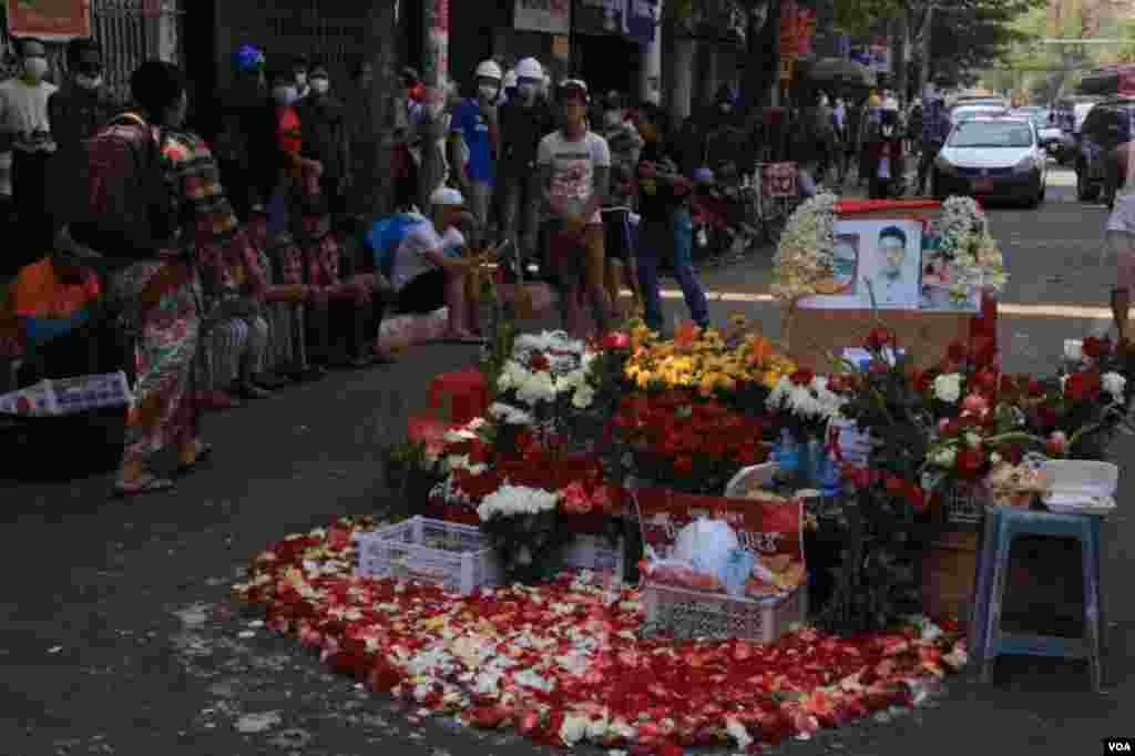 ရန်ကုန် ဆန္ဒပြပွဲအတွင်း သေနတ်ထိမှန်သေဆုံးသူများကို ၎င်းတို့ ကျဆုံးခဲ့ရာနေရာများမှာ ပန်းစည်း ပန်းခြင်းများနဲ့ အောက်မေ့ဂုဏ်ပြုခဲ့ကြတဲ့ မြင်ကွင်း။ (မတ် ၀၁၊ ၂၀၂၁)