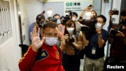 2021年12月29日,身兼《立场新闻》副采访主任的香港记者协会主席陈朗升在离开《立场新闻》 办公室时向在场采访的记者挥手致意