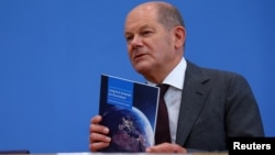 德国总理朔尔茨在柏林举行的记者会上手持国家安全战略。(2023年6月14日)