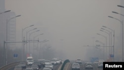 2021 年 2 月 13 日,中国北京,空气污染严重的一天,汽车在道路上行驶。