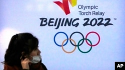 一名女子走过北京冬奥会的大幅广告。(2021年12月9日)