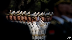 资料照片:一名中国人民解放军士兵正在调整仪仗队成员的帽子 (2016年4月12日,美联社照片)