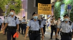 军装警员64日晚在铜锣湾渣甸坊一带举牌警告,驱散聚集悼念六四市民。(美国之音汤惠芸)