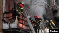 Пожежники ліквідують наслідки влучання російського удару по житловому будинку у Києві, 15 листопада 2022. REUTERS/Gleb Garanich