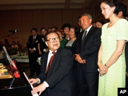 1998年7月3日,中国主席江泽民在哈萨克斯坦的阿拉木图的招待会上弹钢琴,用中文演唱哈萨克歌曲,哈萨克总统(右二)在旁边。