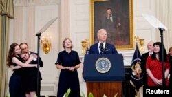 美国总统拜登在白宫就俄罗斯被拘留的美国人获释一事发表讲话,在押人员的家人在他的两侧。