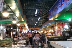 资料照片:顾客在辽宁丹东的一处"湿货市场"挑选海鲜。(2017年8月8日)