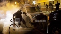 晚上10点过后,抗议者试图向防暴警察扔回催泪瓦斯罐。2015年4月28日,星期二,巴尔的摩,弗雷迪·格雷的葬礼后,周一发生骚乱,宵禁开始生效。(美联社照片)