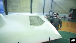 路透社2011年12月8日获得的照片,照片称伊朗革命卫队成员站在被缴获的美国无人机旁