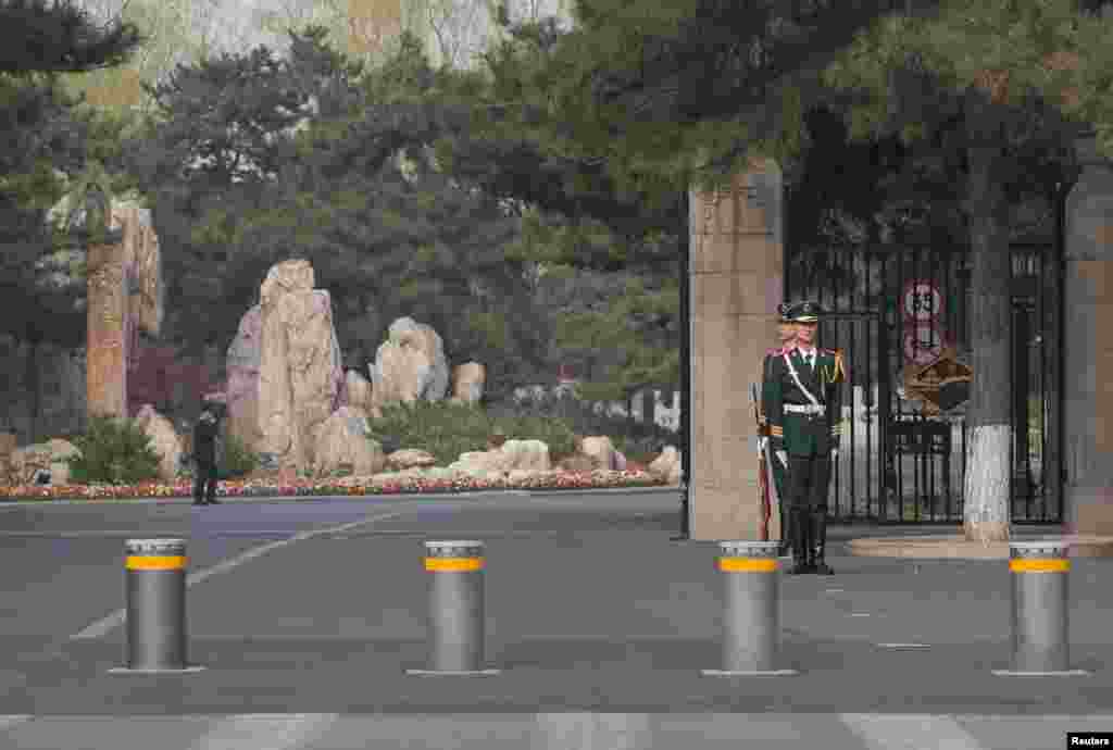 北京钓鱼台国宾馆门口,站岗的两名武警各自监视着一个方向,门口还有路障和奇石,奇石上刻有“钓鱼台”三字。外国政要访问北京时通常住在钓鱼台国宾馆。(2018年3月27日)