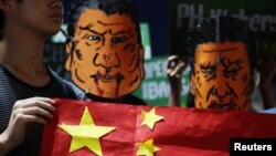 菲律宾学生头戴杜特尔特总统和中国国家主席习近平的漫画脸谱在马尼拉总统府外举行反华示威集会。(2018年11月20日)