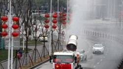 武汉工人在街道上喷洒消毒药水以抗击新冠疫情。(2020年2月10日)