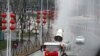 武汉工人在街道上喷洒消毒药水以抗击新冠疫情。（2020年2月10日）