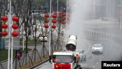 武汉工人在街道上喷洒消毒药水以抗击新冠疫情。(2020年2月10日)