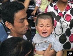 一名因食用毒奶粉而患病等候做超声波检查的儿童在哭泣(资料照片)