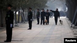 中国武警在北京街道站岗,携带警犬的保安人员在巡逻。(资料照)