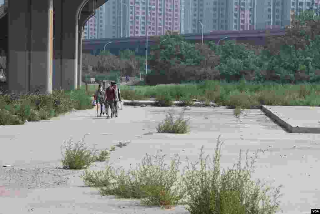 天津爆炸事故现场,核心爆炸区周围多座居民楼窗户被震碎,高速公路桥梁受损,多辆大货车被炸翻,小汽车起火或被砸,多名当地居民仍逗留在事故现场。(美国之音记者东方拍摄)