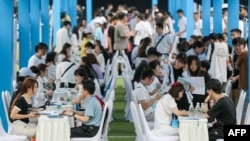 在中国西南部四川省宜宾市,大学毕业生和青年正在参加一场招聘会。(2023年6月14日)