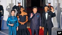 美国总统奥巴马和夫人,中国主席习近平和夫人抵达美国国宴宴会厅时挥手致意(2015年9月25日)