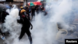 2019年10月1日,中国香港的国庆日,一名反政府示威者在沙田区的一场抗议活动中向其扔催泪弹罐。(资料照)