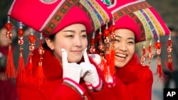 礼仪小姐在人大会议期间在人民大会堂外摆姿势拍照。(2015年3月5日)