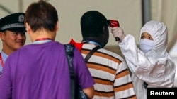 资料照:2014年广东省预防非洲埃博拉病毒,在广州市广交会入口处进行体温测量。(2014年10月26日)