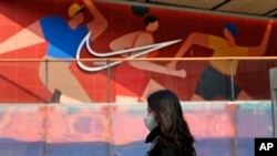 资料照片:2021年3月25日,一名妇女走过北京一家耐克产品专卖店。(美联社照片)