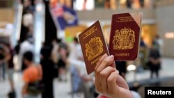 资料照:一名香港示威者在反对港版国安法的抗议中手举英国国民海外护照。(2020年6月1日)