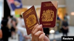 一名香港示威者在反对港版国安法的抗议中手举英国国民海外护照。(2020年6月1日)