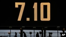 2024年10月6日星期日,在哈马斯袭击以色列一周年纪念日的前夕,在以色列的拉马特甘,人们走过一座写着 7.10 的桥。