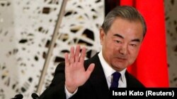 2020年11月24日,时任中国外交部长王毅在日本东京举行的新闻发布会上挥手致意。